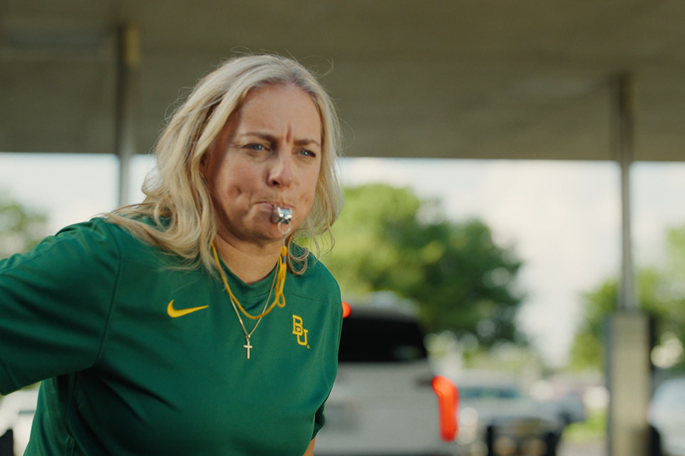 Coach Nicki Collen blows a whistle in the Central National Bank drive-thru